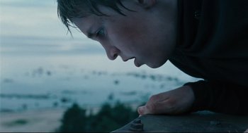 Movie still from “The Return” (2003), directed by Andrey Zvyagintsev – A young man looking down at a piece of wood; Close Up shot, Low angle