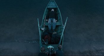 Movie still from “The Return” (2003), directed by Andrey Zvyagintsev – A man is sitting in a boat on the water; Wide shot, Overhead angle