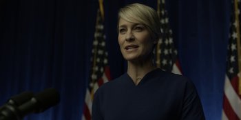 Movie still from “House of Cards” (2013), created by Beau Willimon – A person with a flag in the background; Close Up shot, Low angle