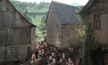 Movie still from “The Return of Martin Guerre” (1982), directed by Daniel Vigne – A group of people sitting on the side of a building; Extreme Wide shot, High angle