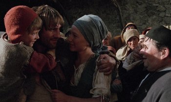 Movie still from “The Return of Martin Guerre” (1982), directed by Daniel Vigne – A group of people gathered around each other in a room; Medium shot, Low angle