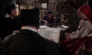 Movie still from “The Return of Martin Guerre” (1982), directed by Daniel Vigne – Two people sitting at a table with papers; Medium shot, High angle