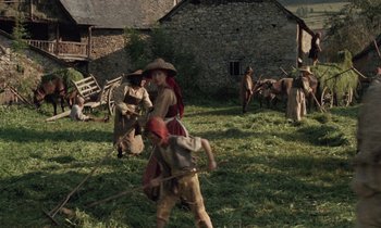 Movie still from “The Return of Martin Guerre” (1982), directed by Daniel Vigne – A group of people standing in the grass; Wide shot, High angle