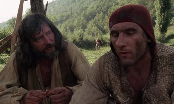 Movie still from “The Return of Martin Guerre” (1982), directed by Daniel Vigne – Two men sitting on the ground in a field; Medium shot, Low angle