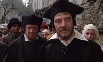 Movie still from “The Return of Martin Guerre” (1982), directed by Daniel Vigne – Two men in medieval garb are standing next to each other; Close Up shot, Over the shoulder angle
