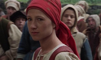 Movie still from “The Return of Martin Guerre” (1982), directed by Daniel Vigne – A woman with a red head scarf and a bunch of other people in the background; Close Up shot, Over the shoulder angle