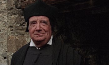 Movie still from “The Return of Martin Guerre” (1982), directed by Daniel Vigne – An older man wearing a black hat and a black robe; Close Up shot, Low angle
