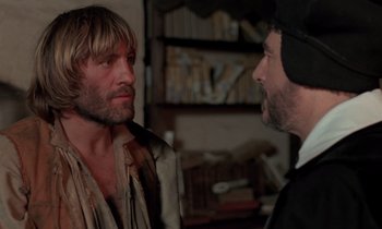 Movie still from “The Return of Martin Guerre” (1982), directed by Daniel Vigne – Two men are standing in a room and one of them is talking to another man; Close Up shot, Over the shoulder angle