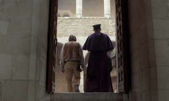 Movie still from “The Return of Martin Guerre” (1982), directed by Daniel Vigne – Two men walking through an archway of a building; Wide shot, Low angle