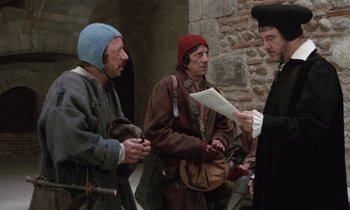 Movie still from “The Return of Martin Guerre” (1982), directed by Daniel Vigne – A group of men standing next to each other on a street; Medium shot, Over the shoulder angle