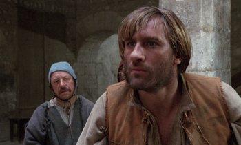 Movie still from “The Return of Martin Guerre” (1982), directed by Daniel Vigne – Two men in medieval garb looking at the camera; Close Up shot, Over the shoulder angle