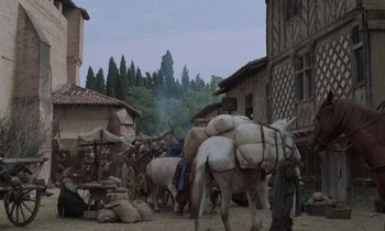 Movie still from “The Return of Martin Guerre” (1982), directed by Daniel Vigne – A group of people on a dirt road with horses; Extreme Wide shot, High angle