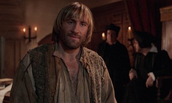 Movie still from “The Return of Martin Guerre” (1982), directed by Daniel Vigne – A man with long hair standing in a room; Close Up shot, Over the shoulder angle