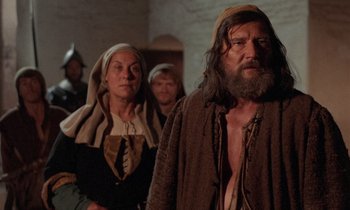 Movie still from “The Return of Martin Guerre” (1982), directed by Daniel Vigne – A group of people standing next to each other in a room; Medium shot, Low angle