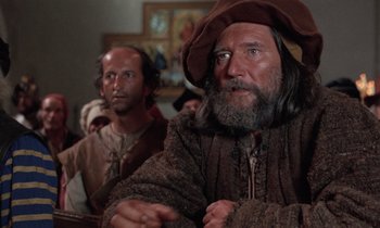 Movie still from “The Return of Martin Guerre” (1982), directed by Daniel Vigne – A man with long hair and a beard wearing a brown hat; Close Up shot, Low angle