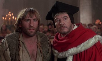 Movie still from “The Return of Martin Guerre” (1982), directed by Daniel Vigne – Two men in medieval garb standing next to each other; Close Up shot, Over the shoulder angle