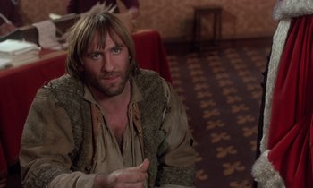 Movie still from “The Return of Martin Guerre” (1982), directed by Daniel Vigne – A man with long brown hair sitting in a room; Close Up shot, Over the shoulder angle
