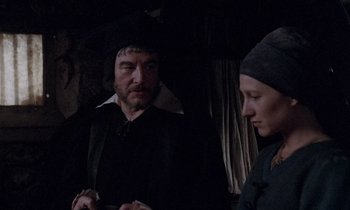 Movie still from “The Return of Martin Guerre” (1982), directed by Daniel Vigne – A man and a woman standing next to each other in a dark room; Medium shot, Over the shoulder angle