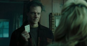 Movie still from “The Ring” (2002), directed by Gore Verbinski – A man holding a card in front of a mirror; Close Up shot, Over the shoulder angle