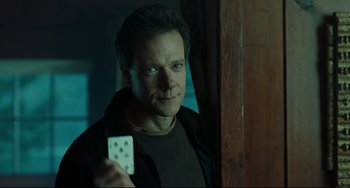 Movie still from “The Ring” (2002), directed by Gore Verbinski – A man holding a remote control in his hand; Close Up shot, Over the shoulder angle