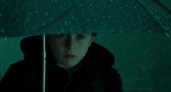 Movie still from “The Ring” (2002), directed by Gore Verbinski – A young boy is under an umbrella in the dark; Close Up shot, Low angle