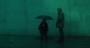 Movie still from “The Ring” (2002), directed by Gore Verbinski – Two people standing under an umbrella on a rainy day; Wide shot, Low angle