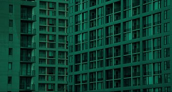 Movie still from “The Ring” (2002), directed by Gore Verbinski – A building with many balconies and windows in a city; Extreme Wide shot, Overhead angle