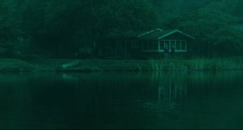 Movie still from “The Ring” (2002), directed by Gore Verbinski – Two people standing in front of a house by the water; Extreme Wide shot, High angle