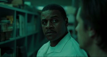 Movie still from “The Ring” (2002), directed by Gore Verbinski – A man in a lab coat is looking at the camera; Close Up shot, Over the shoulder angle