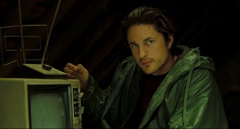 Movie still from “The Ring” (2002), directed by Gore Verbinski – A man in a green raincoat is holding a television; Close Up shot, Low angle