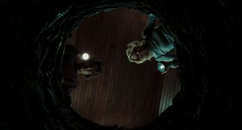 Movie still from “The Ring” (2002), directed by Gore Verbinski – Two people standing in the dark with a flashlight; Wide shot, Overhead angle