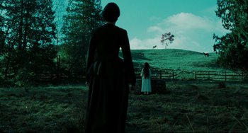 Movie still from “The Ring” (2002), directed by Gore Verbinski – Two people in a field with a cow in the background; Wide shot, Low angle