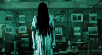 Movie still from “The Ring” (2002), directed by Gore Verbinski – A woman with long black hair standing in a room; Medium shot, Over the shoulder angle