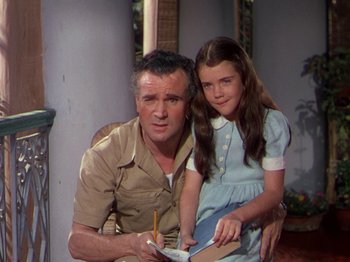 Movie still from “The River” (1951), directed by Jean Renoir – A man and a little girl sitting next to each other; Medium shot, High angle