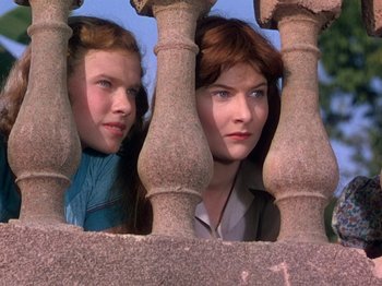 Movie still from “The River” (1951), directed by Jean Renoir – Two women looking through a fence at a park; Close Up shot, Low angle