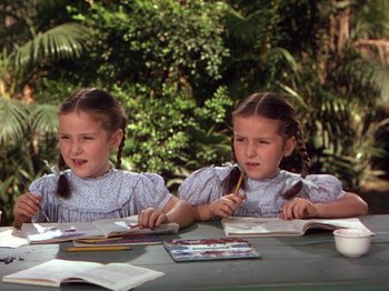 Movie still from “The River” (1951), directed by Jean Renoir – Two little girls sitting at a table doing homework; Medium shot, High angle
