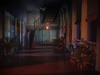 Movie still from “The River” (1951), directed by Jean Renoir – A man walking down the stairs of a building; Extreme Wide shot, Low angle