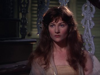 Movie still from “The River” (1951), directed by Jean Renoir – A woman with long brown hair wearing a white dress; Close Up shot, Over the shoulder angle