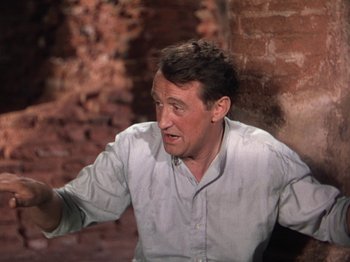 Movie still from “The River” (1951), directed by Jean Renoir – A man in a white dress shirt is sitting in a room; Close Up shot, Over the shoulder angle