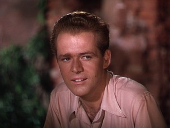 Movie still from “The River” (1951), directed by Jean Renoir – A person wearing a pink shirt; Close Up shot, Low angle