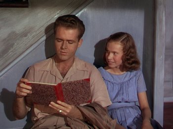 Movie still from “The River” (1951), directed by Jean Renoir – A man and a little girl sitting next to each other; Medium shot, High angle