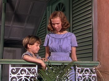 Movie still from “The River” (1951), directed by Jean Renoir – A woman and a young boy standing on a balcony; Medium shot, Low angle
