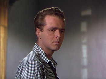 Movie still from “The River” (1951), directed by Jean Renoir – A man in a checkered dress shirt and tie; Close Up shot, Low angle