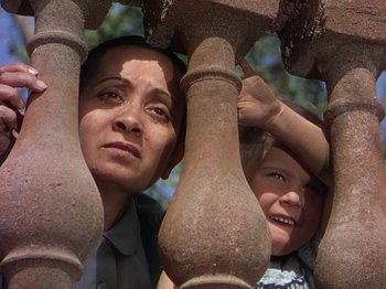 Movie still from “The River” (1951), directed by Jean Renoir – A woman and a child looking over a fence; Close Up shot, Low angle