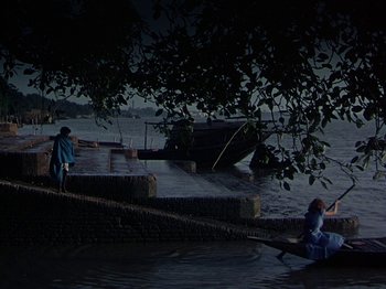 Movie still from “The River” (1951), directed by Jean Renoir – Two people in a body of water near a dock; Extreme Wide shot, High angle
