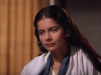 Movie still from “The River” (1951), directed by Jean Renoir – A woman with long black hair wearing a white shirt; Close Up shot, High angle