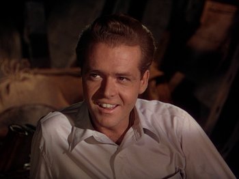 Movie still from “The River” (1951), directed by Jean Renoir – A man in a white dress shirt smiling for the camera; Close Up shot, Low angle