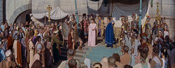 Movie still from “The Robe” (1953), directed by Henry Koster – A group of men and women dressed as roman soldiers and women dressed as roman soldiers; Wide shot, High angle