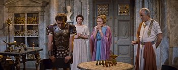 Movie still from “The Robe” (1953), directed by Henry Koster – A group of people standing next to each other in a room; Medium shot, Over the shoulder angle