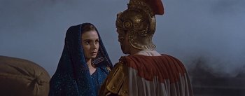 Movie still from “The Robe” (1953), directed by Henry Koster – A woman and a man in roman garb stand side by side; Close Up shot, Over the shoulder angle